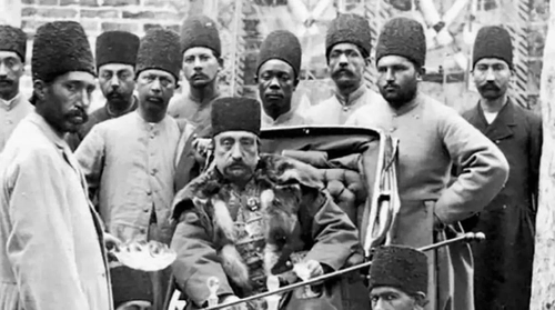 تصویری از درباریان ناصرالدین شاه در حال بررسی عیار سکه