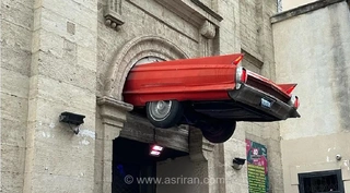 کادیلاک قرمز در نمای یک بنای تاریخی در فرانسه