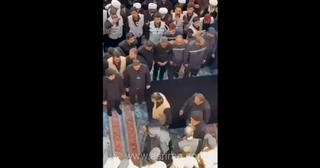 ورود آیت الله سید محمد تقی الحکیم به حرم امام علی (ع) برای اقامه نماز بر پیکر رهبر شهید ایران